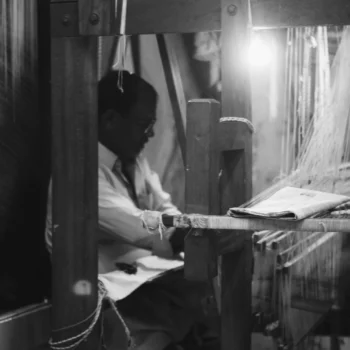 About Us 2 free-photo-of-a-man-working-on-a-loom-in-a-dark-room